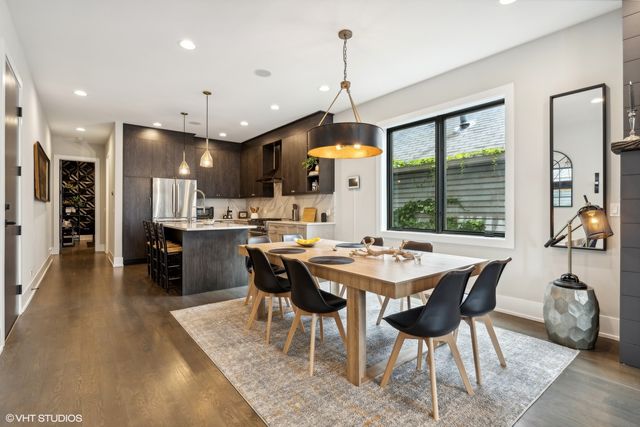 a kitchen with stainless steel appliances granite countertop a table chairs and a refrigerator