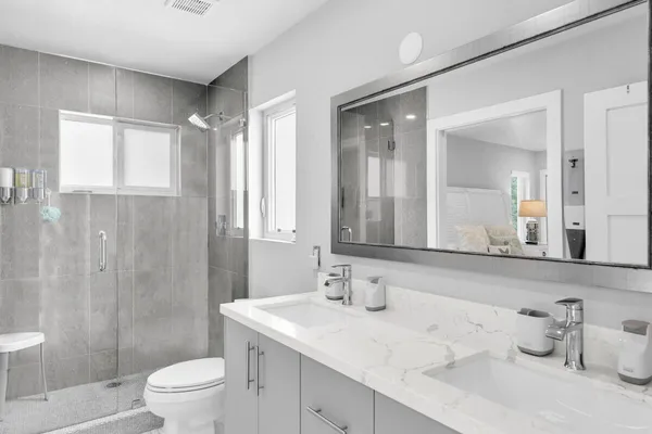 a bathroom with a sink a toilet and shower