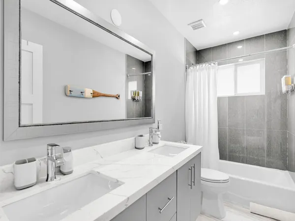 a bathroom with a granite countertop sink toilet and shower
