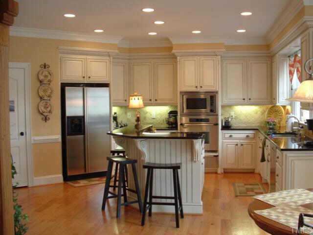 10525 Charmford Way Raleigh, NC 27615 - Photo 3 of 12 a kitchen with kitchen island granite countertop wooden cabinets and stainless steel appliances