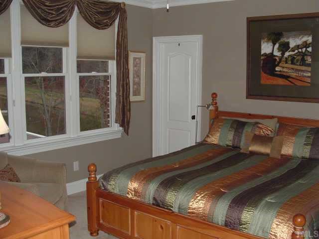 10525 Charmford Way Raleigh, NC 27615 - Photo 7 of 12 a bedroom with a bed and a painting on the wall