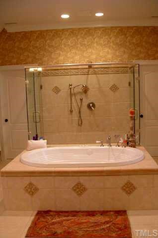 10525 Charmford Way Raleigh, NC 27615 - Photo 8 of 12 a bathroom with a bathtub and shower