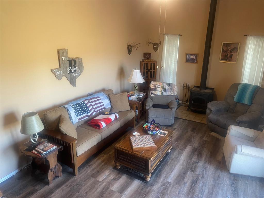 12301 Highway 36 Comanche, TX 76442 - Photo 24 of 28 Living room featuring wood finished floors and a wood stove