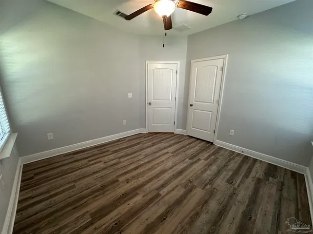 a view of a room with wooden floor closet and chandelier fan