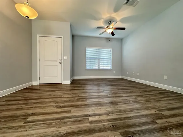 a view of a room with wooden floor and chandelier fan