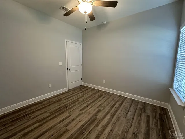 a view of an empty room with wooden floor