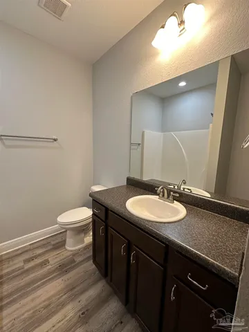 a bathroom with a granite countertop sink a toilet and a mirror