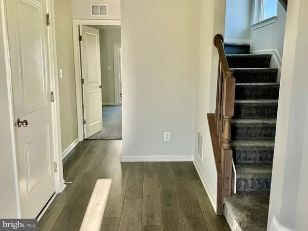 a view of a hallway with wooden floor and entryway