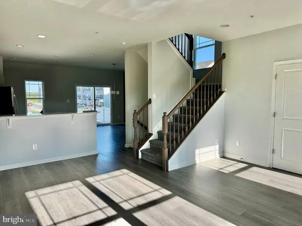 a view of a hallway with wooden floor and stairs