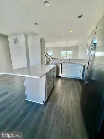 a view of a kitchen with wooden floor and electronic appliances