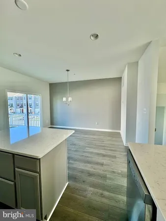 a view of kitchen island a sink wooden floor and entryway