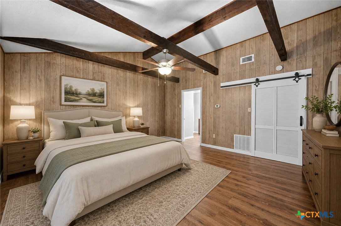 102 Rivercrest Street Luling, TX 78648 - Photo 11 of 36 a spacious bedroom with a bed and a painting on the wall