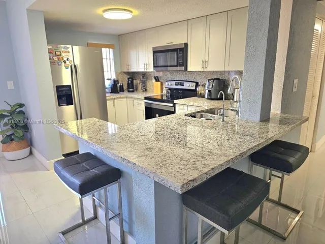 a kitchen with a table chairs and microwave