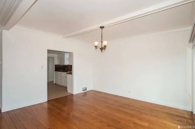 a view of empty room with wooden floor and cabinet