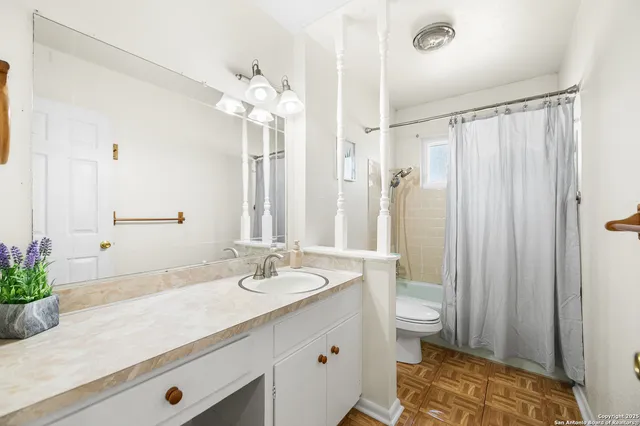 a bathroom with a double vanity sink mirror and toilet