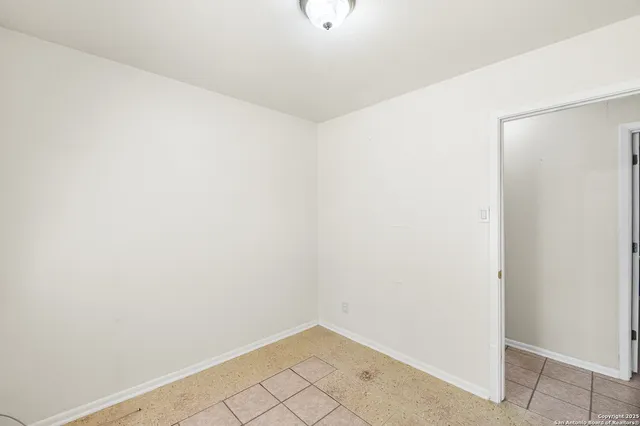 an empty room with a ceiling fan and a window