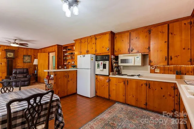 a kitchen with stainless steel appliances granite countertop a refrigerator a stove a sink dishwasher and wooden cabinets with wooden floor