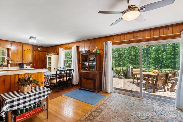 a living room with furniture a flat screen tv and floor to ceiling windows