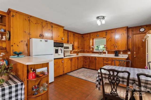 a kitchen with stainless steel appliances wooden cabinets a stove a sink and a refrigerator