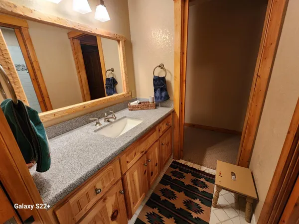 a bathroom with a granite countertop sink and a mirror