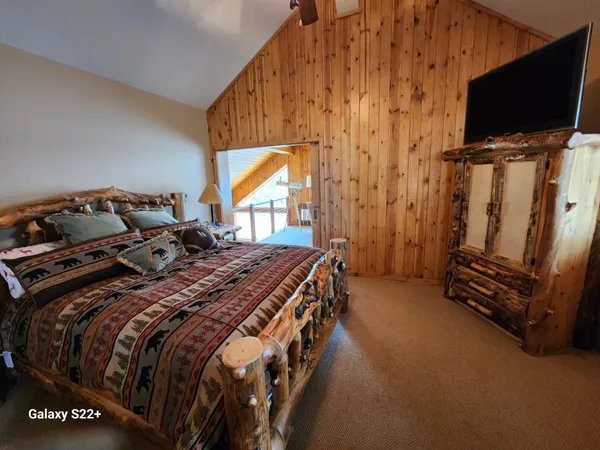 a bedroom with a bed and flat screen tv