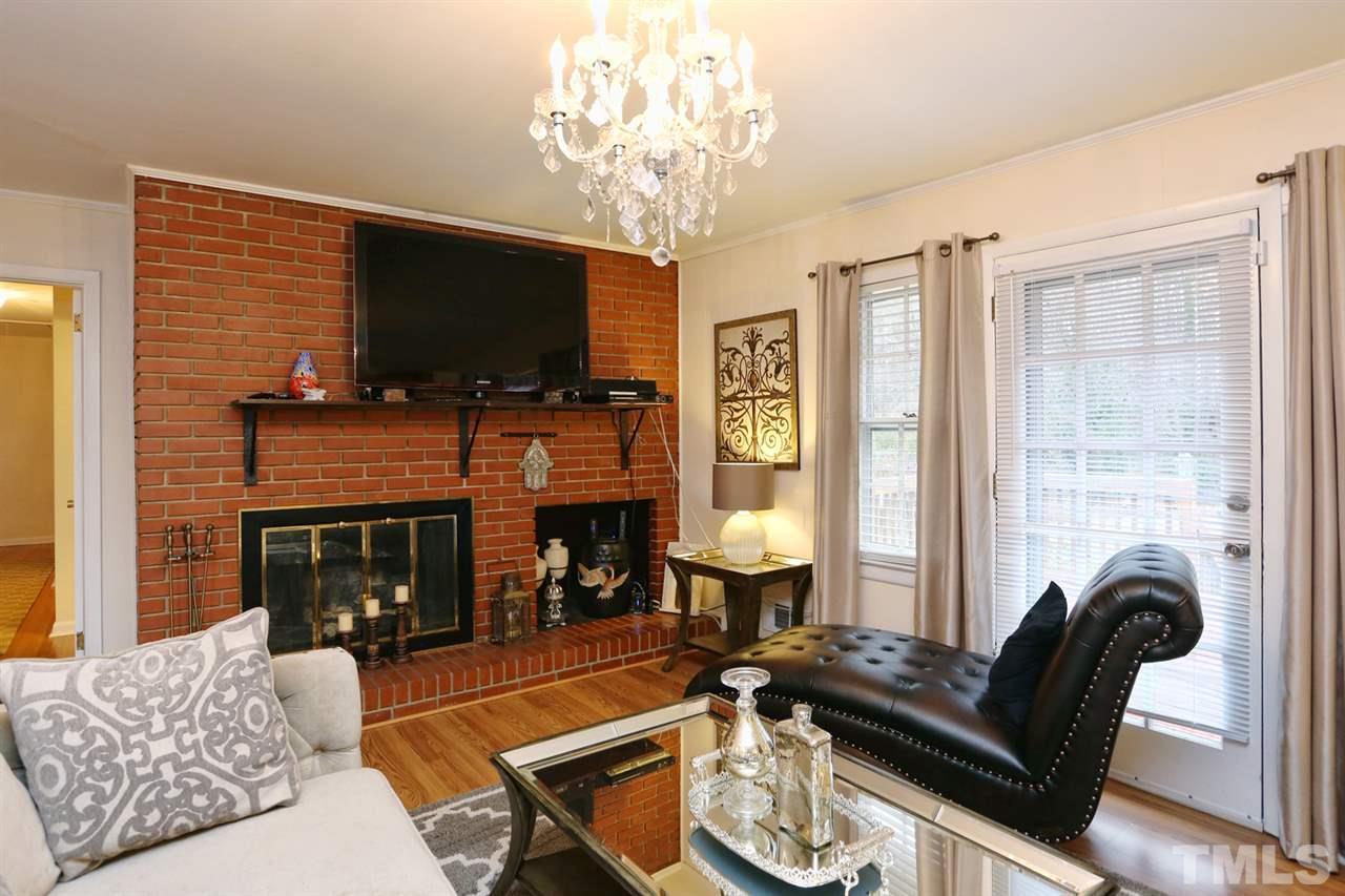 3917 Buffaloe Road Raleigh, NC 27604 - Photo 8 of 24 a living room with furniture a flat screen tv and a fireplace