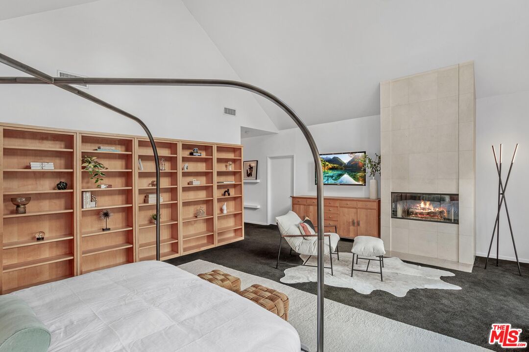 4216 Woodcliff Road Sherman Oaks, CA 91403 - Photo 14 of 56 a bedroom with a bed and a bookshelf with wooden floor