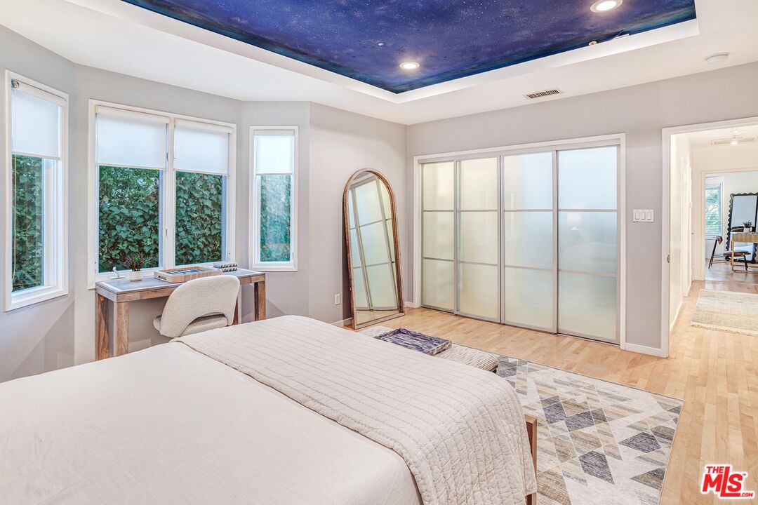 4216 Woodcliff Road Sherman Oaks, CA 91403 - Photo 27 of 56 a bedroom with a large bed and a large window