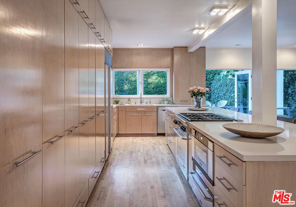 4216 Woodcliff Road Sherman Oaks, CA 91403 - Photo 7 of 56 a kitchen with granite countertop a sink a counter top space and stainless steel appliances