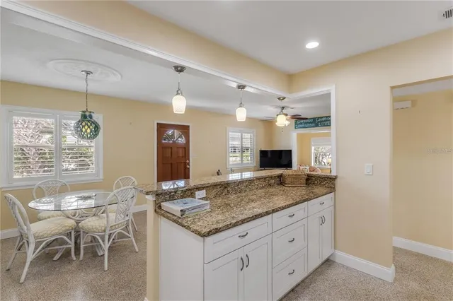 a view of a kitchen island a chandelier and living room view