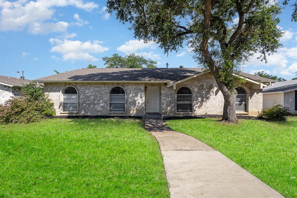 Ranch-style house with brick siding, a front yard, and a shingled roof