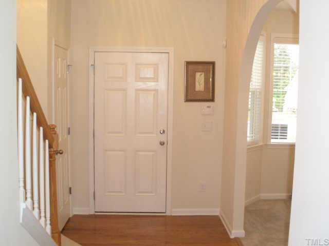 4415 Log Cabin Drive Raleigh, NC 27616 - Photo 7 of 10 The entry features hardwood floors with security pad for easy access. Note the beautiful architectural detail of the arch into the diningroom with its bay window. Elegant banisters make a beautiful entry.