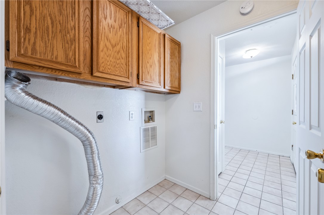 2524 South Ridge Avenue Bullhead City, AZ 86429 - Photo 47 of 64 Laundry area with cabinet space, hookup for an electric dryer, gas dryer hookup, and light tile patterned flooring