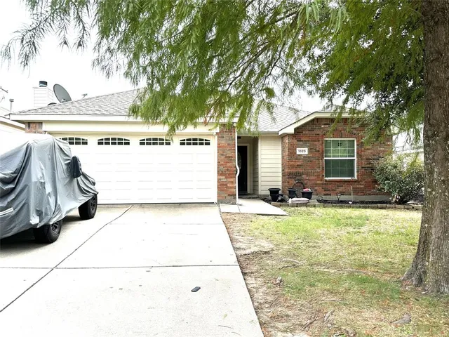 a view of a patio with a table and chairs under an umbrella
