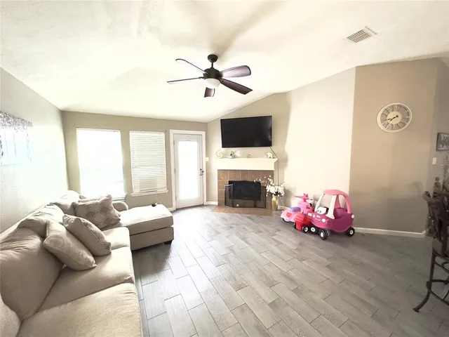 a living room with furniture a fireplace and a flat screen tv