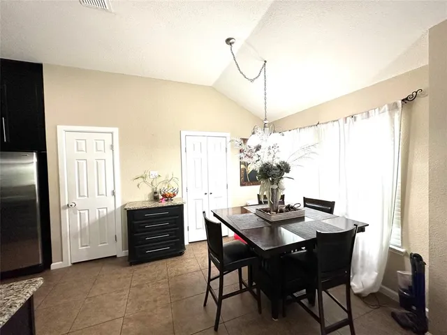 a dining room with furniture a chandelier and window