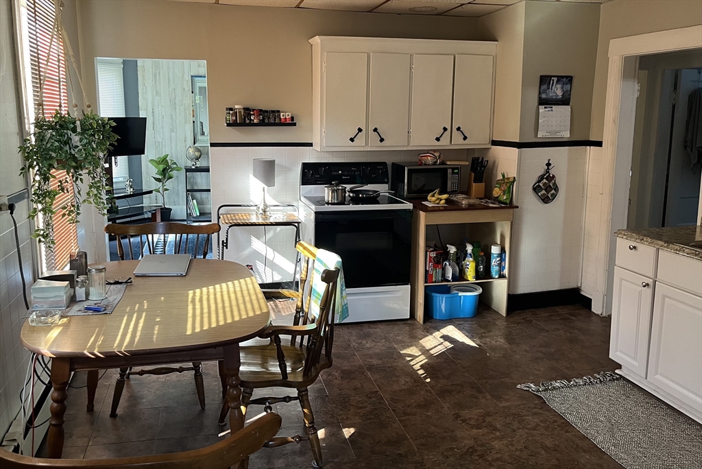 83 Madison Street Chicopee, MA 01020 - Photo 5 of 5 a kitchen with stainless steel appliances granite countertop a stove a refrigerator a dining table and chairs