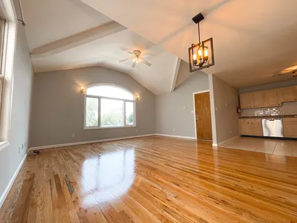 a view of a room with a ceiling fan and wooden floor