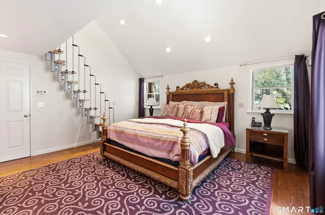a bedroom with a bed and wooden floor