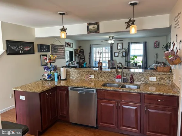 a kitchen with kitchen island granite countertop a sink cabinets and window