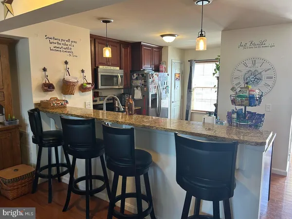 a kitchen with granite countertop a table chairs stove and cabinets