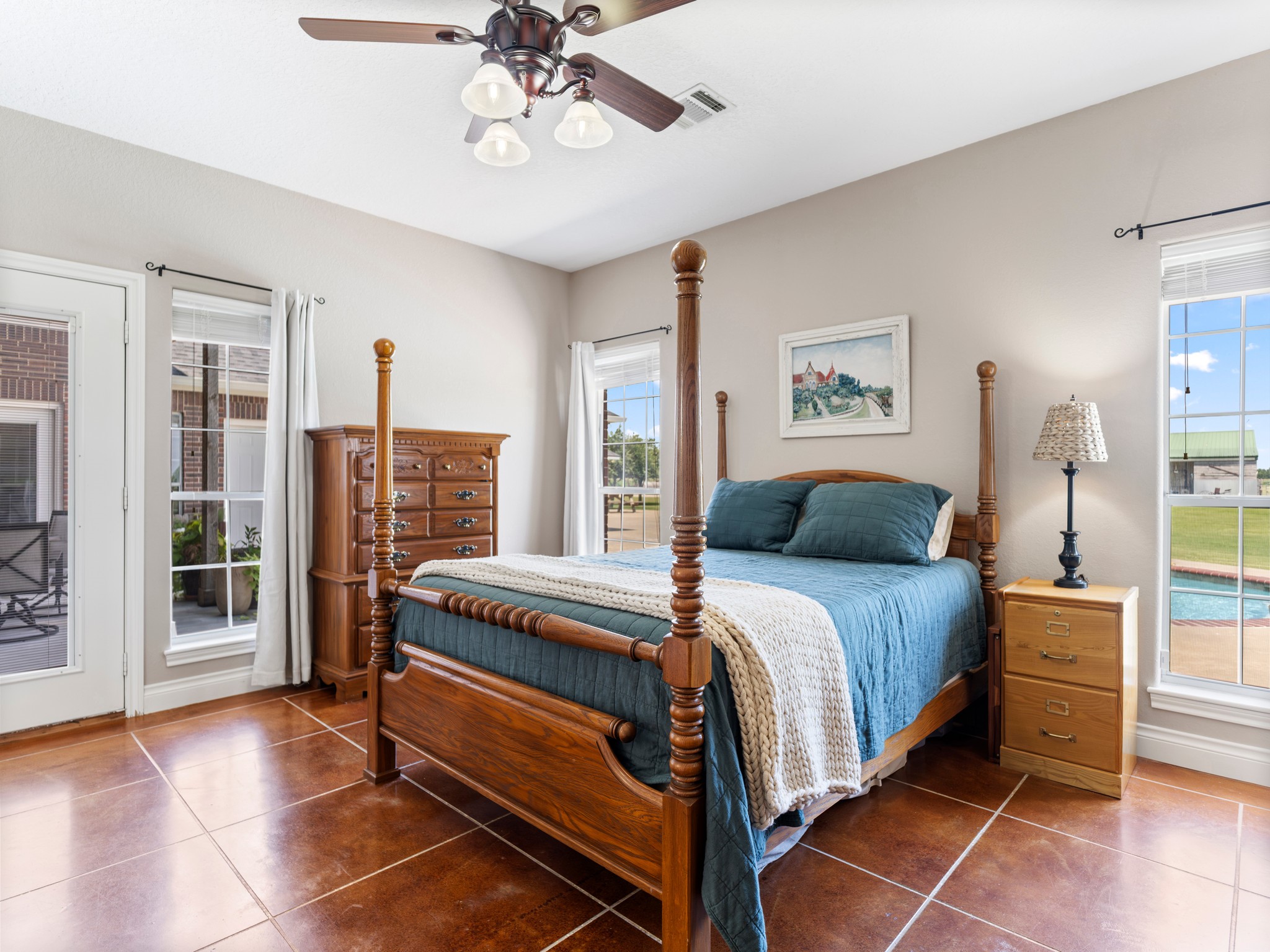 10630 Brinkmeyer Road Needville, TX 77461 - Photo 29 of 50 a spacious bedroom with a bed and a chandelier