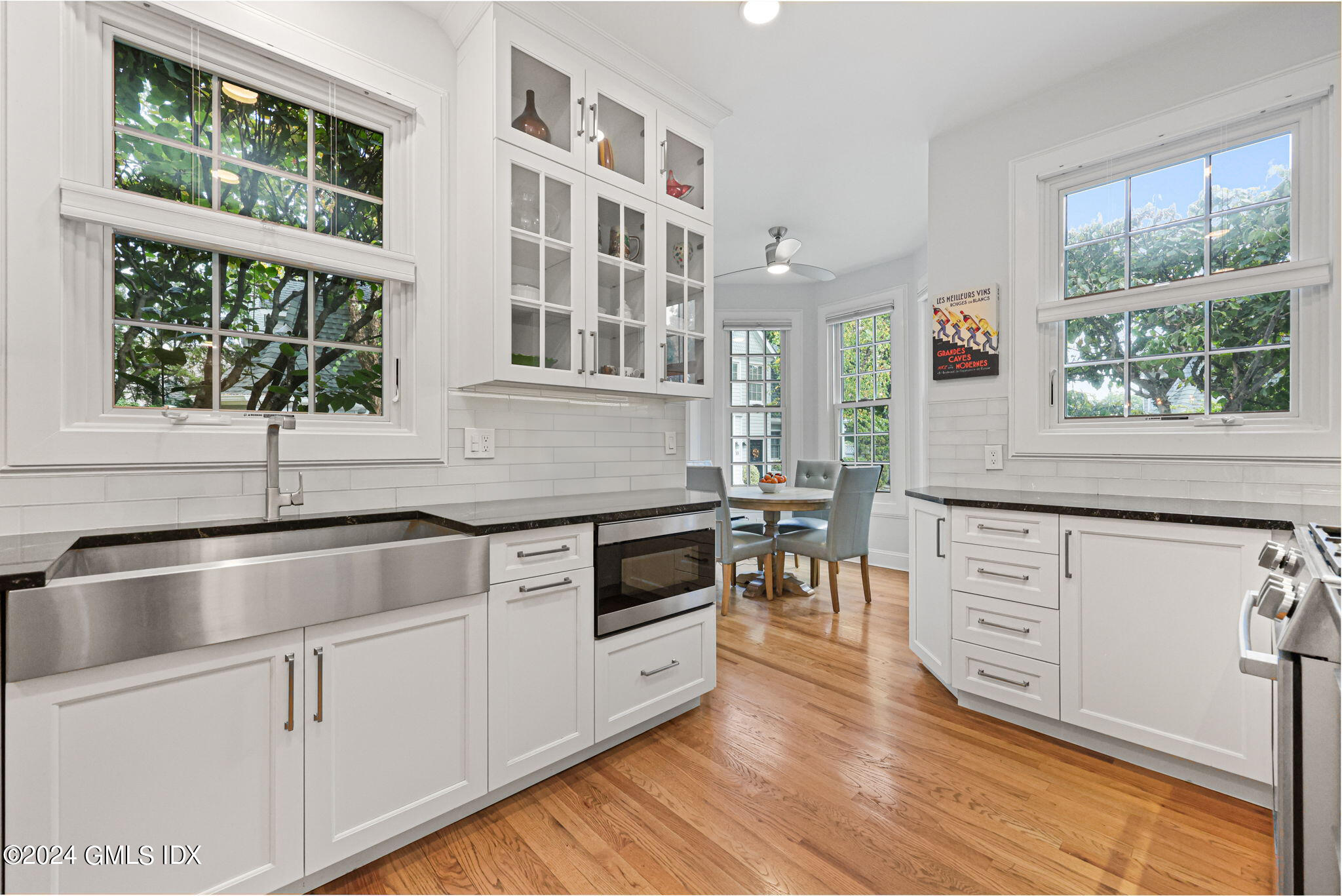 48 Spring Street, Unit 8 Greenwich, CT 06830 - Photo 12 of 24 a kitchen with stainless steel appliances granite countertop a stove and white cabinets