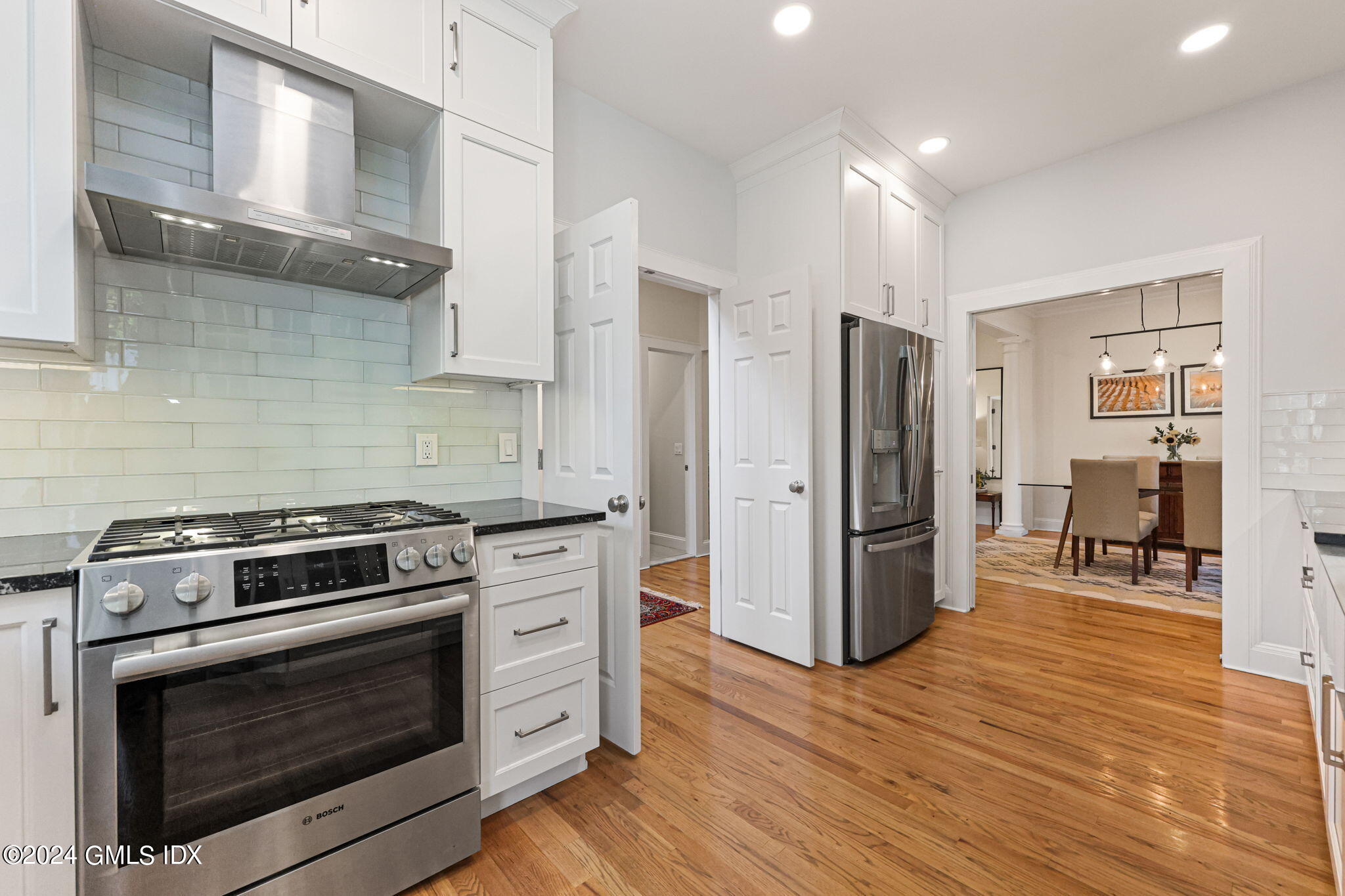 48 Spring Street, Unit 8 Greenwich, CT 06830 - Photo 14 of 24 a kitchen with stainless steel appliances wooden floor sink and wooden cabinets