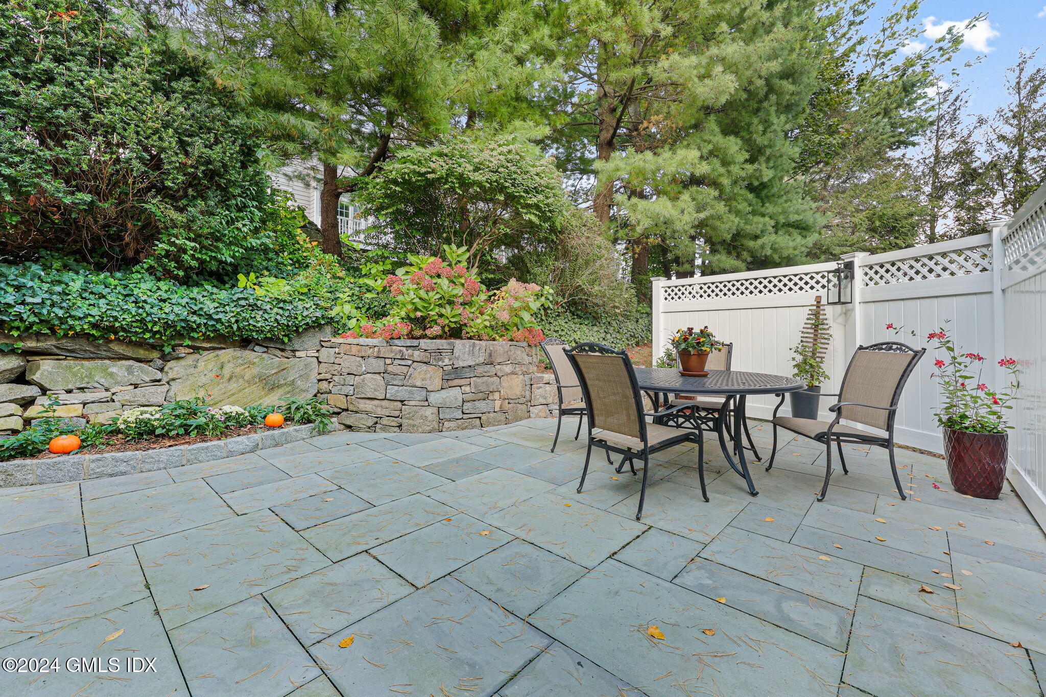 48 Spring Street, Unit 8 Greenwich, CT 06830 - Photo 9 of 24 a view of a patio with table and chairs and potted plants