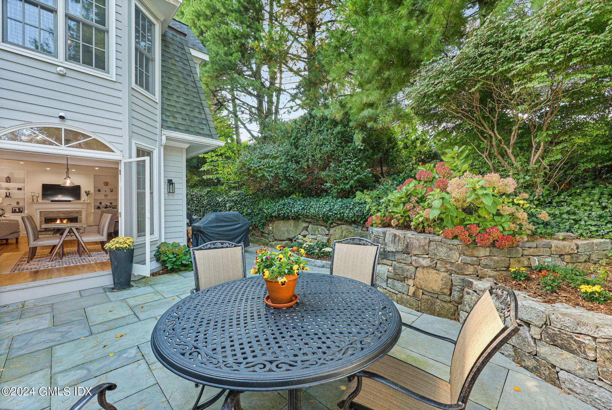 48 Spring Street, Unit 8 Greenwich, CT 06830 - Photo 10 of 24 a view of a backyard with table and chairs potted plants and tree