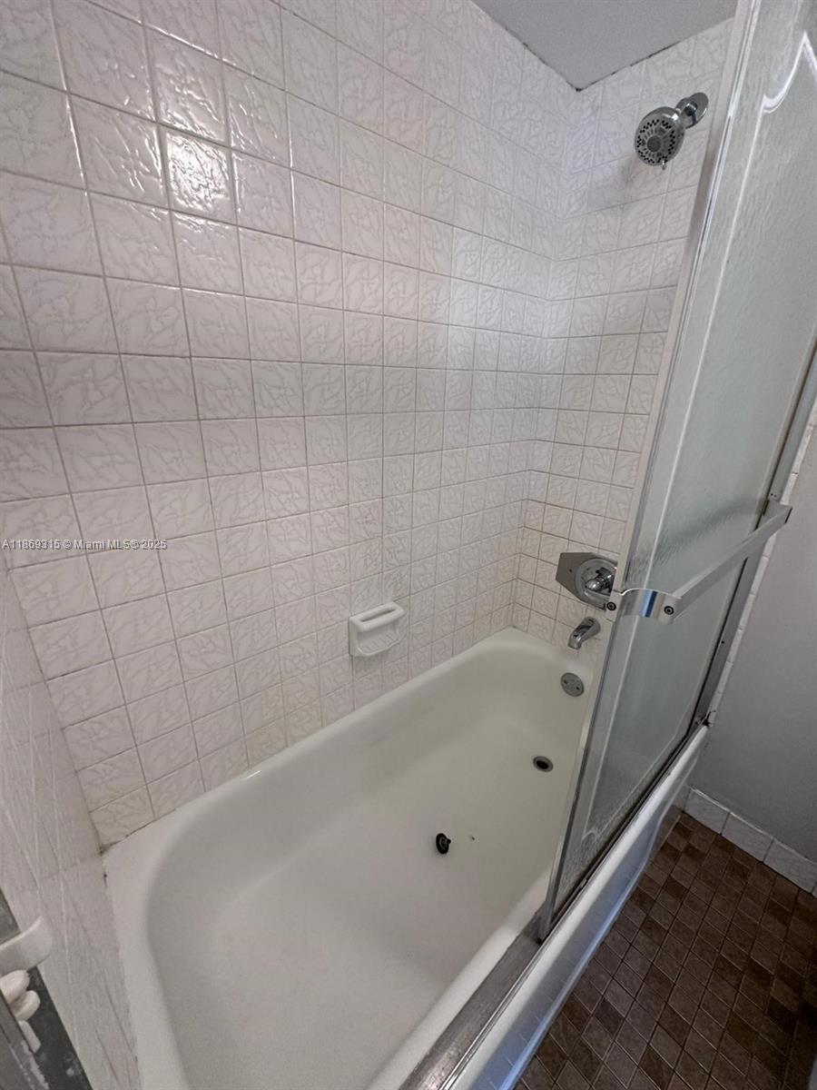 3390 Foxcroft Road, Unit C212 Miramar, FL 33025 - Photo 13 of 16 a bathroom with a white bath tub and a shower