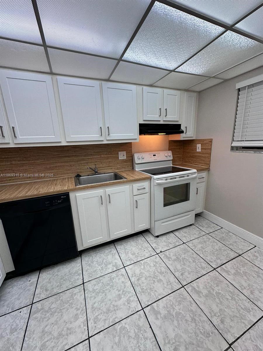 3390 Foxcroft Road, Unit C212 Miramar, FL 33025 - Photo 4 of 16 a kitchen with cabinets and appliances