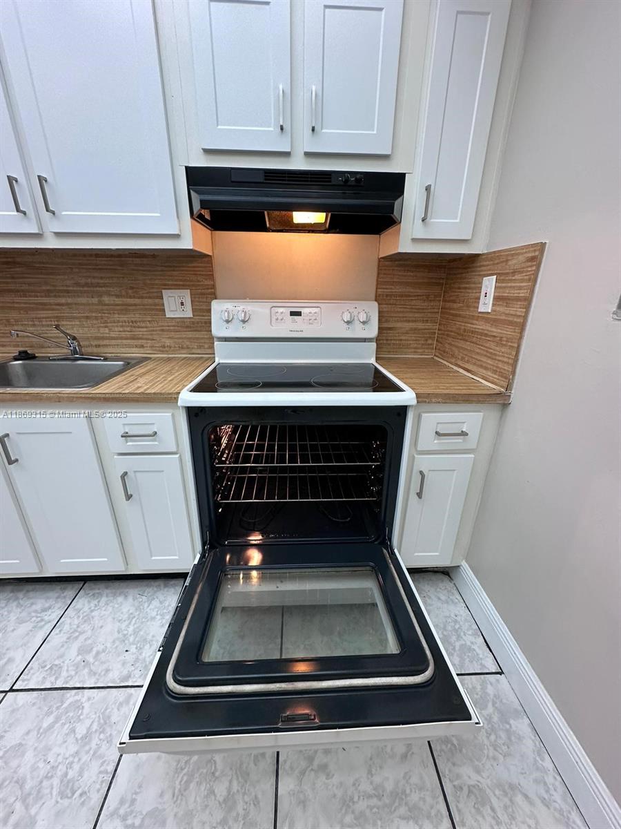 3390 Foxcroft Road, Unit C212 Miramar, FL 33025 - Photo 5 of 16 a stove top oven sitting inside of a kitchen