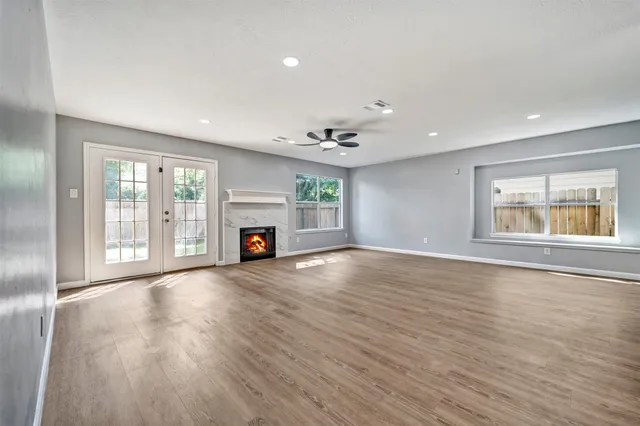 a view of empty room with wooden floor and fireplace